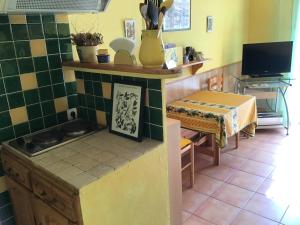 - une cuisine avec une cuisinière et une table dans une chambre dans l'établissement Gîte des oliviers, au Luc