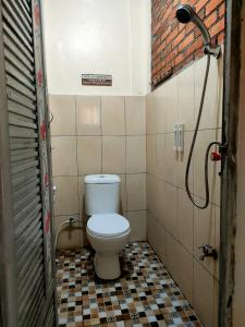 Un pequeño baño con inodoro en una habitación. en Paviliun Omah Ndanu, en Yogyakarta