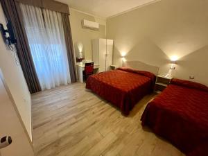 a hotel room with two beds and a desk at Pisani Hotel in San Nicola La Strada +48 photos