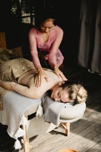 a woman giving a young girl a massage on a bed at Magical Jungle Resort in Ubud