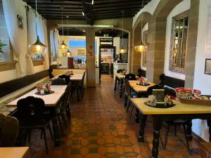 a restaurant with wooden tables and chairs in a room at Hotel Zum Goldenen Anker in Bamberg
