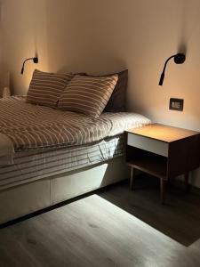 a bedroom with a bed with a nightstand and two lamps at Studio N in Beirut