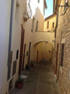 un callejón en un edificio antiguo con un arco en Relax Centro storico en Rapolano Terme