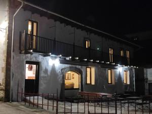 a black building with a balcony and some tables at Casa Xauri in Aria