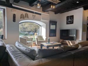 a living room with a leather couch and a tv at Casa Xauri in Aria
