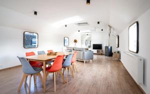a dining room and living room with a table and chairs at Arcadia - Péniche de Standing à Namur avec vue sur la Citadelle in Namur
