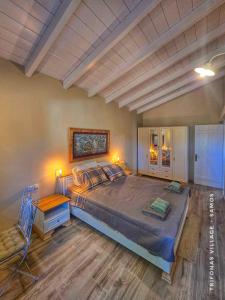 a bedroom with a large bed and a wooden floor at Trifonas village in Karlovasi +47 photos