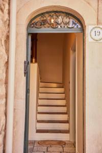 a hallway with stairs in a building with a clock at Dimora Storica a Trani con Terrazzo Jacuzzi x Dimora Storica a Trani con Terrazzo e Jacuzzi con 6 Posti Letto e Aria Condizionata in Trani