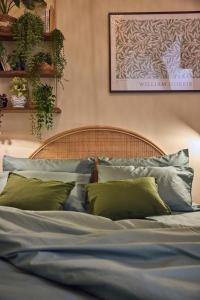 a bed with blue sheets and green pillows at Dimora Storica a Trani con Terrazzo Jacuzzi x Dimora Storica a Trani con Terrazzo e Jacuzzi con 6 Posti Letto e Aria Condizionata in Trani