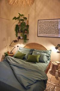a bed with blue sheets and green pillows in a bedroom at Dimora Storica a Trani con Terrazzo Jacuzzi x Dimora Storica a Trani con Terrazzo e Jacuzzi con 6 Posti Letto e Aria Condizionata in Trani