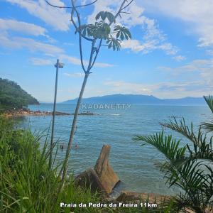 een uitzicht op een strand met een kruis in het water bij Casa Ventilada e Confortável, Perto da Rodovia e 2km da Praia in Caraguatatuba