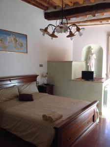 1 dormitorio con 1 cama grande y una estatua en la pared en Relax Centro storico en Rapolano Terme