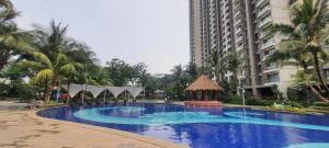 une grande piscine bleue en face d'un grand bâtiment dans l'établissement Cheapest 3 Bedroom Apartment in Sky House BSD - Duxton 1, à Samporo