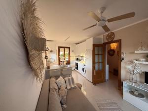 een woonkamer met een bank en een plafondventilator bij Hippie und Famila Paraiso in Cala d´Or