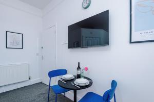 a dining room with a table and chairs and a tv at Jephsons Lodge Studio 7 - Town Centre, WiFi, Free Disney & Prime in Leamington Spa +13 photos