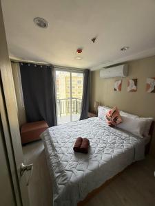 a bedroom with a large bed and a window at Cityscape Grand Tower Cebu - 2 Bedrooms with Balcony Close to Ayala Mall - New Condo in Cebu City