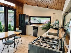 a kitchen with a stove and a table and a counter top at Casa Fratila in Holbav