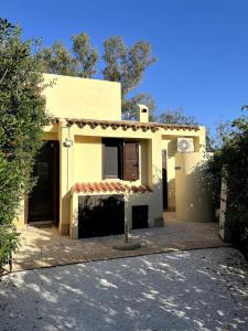 哥斯达雷Villetta Solemari - 100m from the beach的一条有车道的小黄色房子