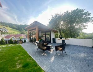 a patio with chairs and a table in a yard at Casa Fratila in Holbav