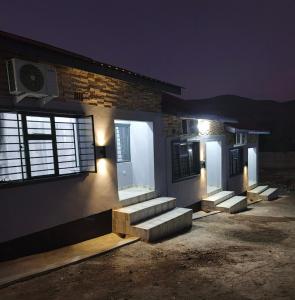 a house with stairs on the side of it at night at Taurus Apartments in Chipata +4 photos