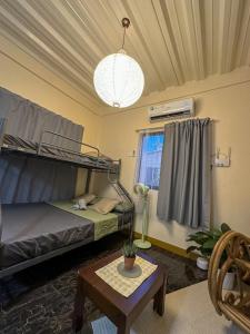 a room with two bunk beds and a table at Stylish Studio Near Kabsat Surf Spots Urbiztondo San Juan LU in San Juan