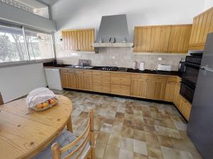 a kitchen with wooden cabinets and a table with a bowl of fruit at Villa San Michele - 70's experience in Salernes