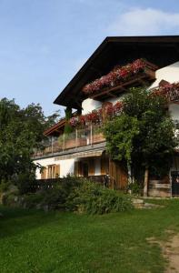 a building with a balcony with flowers on it at Residence Streitlhof in Tirolo +17 photos