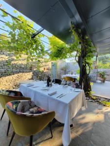 a table with white tables and yellow chairs in a room at Locanda Gaudemus Boutique Hotel in Sistiana