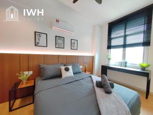 a bedroom with a large bed and a desk at Ipoh Meru 3 Bedroom Suites by IWH Suites in Ipoh