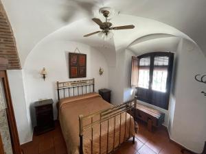 a bedroom with a bed and a ceiling fan at Casa Rural El Verdinal in Villanueva del Duque +19 photos