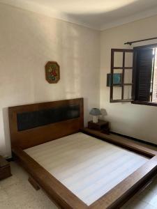 a large bed in a bedroom with a clock on the wall at Magnifique étage de villa à 2 minutes de la plage in Nabeul +26 photos