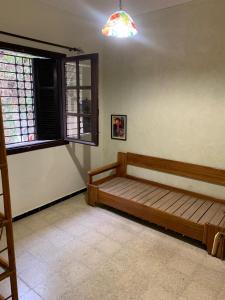a room with a wooden bed and a window at Magnifique étage de villa à 2 minutes de la plage in Nabeul