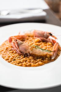 a plate of food with a crab on top of beans at Locanda Gaudemus Boutique Hotel in Sistiana