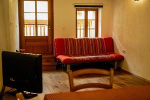 a living room with a red couch and a tv at Apartment Bernarda - Entire House in Kobarid
