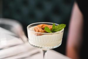 a dessert in a glass with a mint leaf on top at Locanda Gaudemus Boutique Hotel in Sistiana