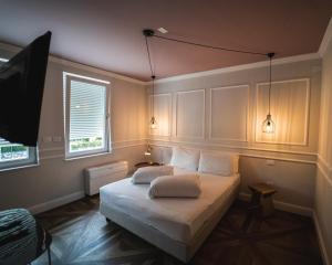 a bedroom with a bed with two pillows on it at Locanda Gaudemus Boutique Hotel in Sistiana