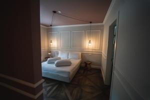 a small bedroom with a bed with two pillows at Locanda Gaudemus Boutique Hotel in Sistiana