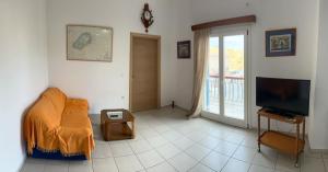 ein Wohnzimmer mit Sofa und Fernseher in der Unterkunft Captain's Lodge in Ermoupoli