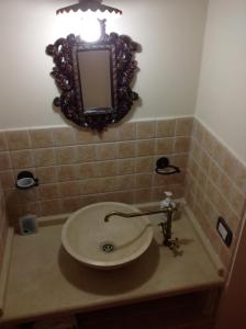 baño con lavabo y espejo en la pared en Relax Centro storico en Rapolano Terme