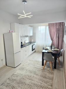 a kitchen with a table and a white refrigerator at Enjoy my Home near Palas Mall 2 in Iaşi +24 photos