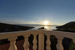 a view of the ocean from a balcony with the sun at Apartmani Marko in Gdinj