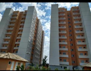 2 grands immeubles d'appartements en face d'un ciel bleu dans l'établissement Apartamento Aconchegante Esteio - Coração da Grande Porto Alegre, à Esteio