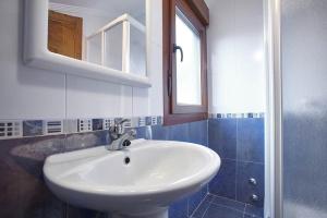 a bathroom with a white sink and a mirror at Urbanización Barrio de Triana 3c in Nueva de Llanes +19 photos