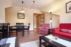 a living room with a red couch and a table at Urbanización Barrio de Triana 3c in Nueva de Llanes