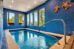 una piscina cubierta con paredes azules y una pared azul en Tranquil Mountain Getaway By Ghosal Luxury Lodging, en Gatlinburg