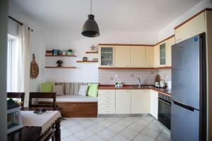 a kitchen with white cabinets and a couch in the background at Mare nostrum - Alykes Zakynthou in Alykes +38 photos