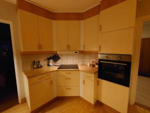 a kitchen with yellow cabinets and a black appliance at Villa i Näsland in Näsland +33 photos