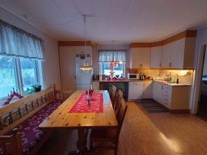 a kitchen with a wooden table and a dining room at Villa i Näsland in Näsland