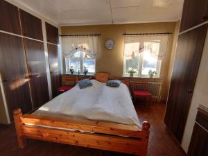 a bedroom with a large bed and two windows at Villa i Näsland in Näsland