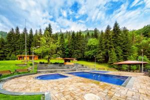 a swimming pool in the middle of a park at Sadgeri Cottage Retreat in Borjomi in Sadgeri